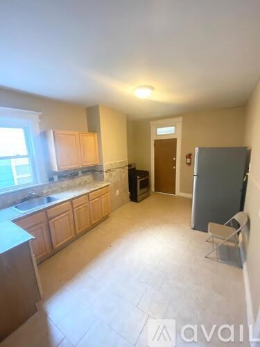 A kitchen with wooden cabinets and a refrigerator.