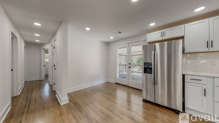 A kitchen with white cabinets and a stainless steel refrigerator.