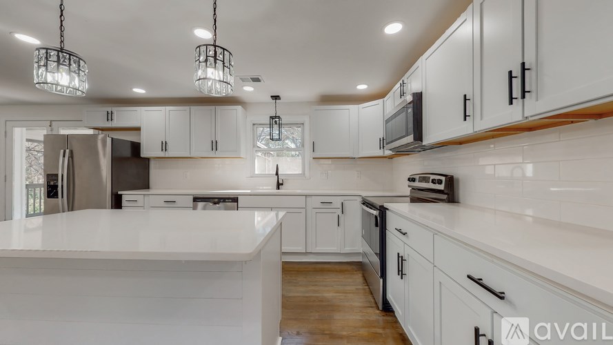 A modern kitchen with white countertops and wooden cabinets.