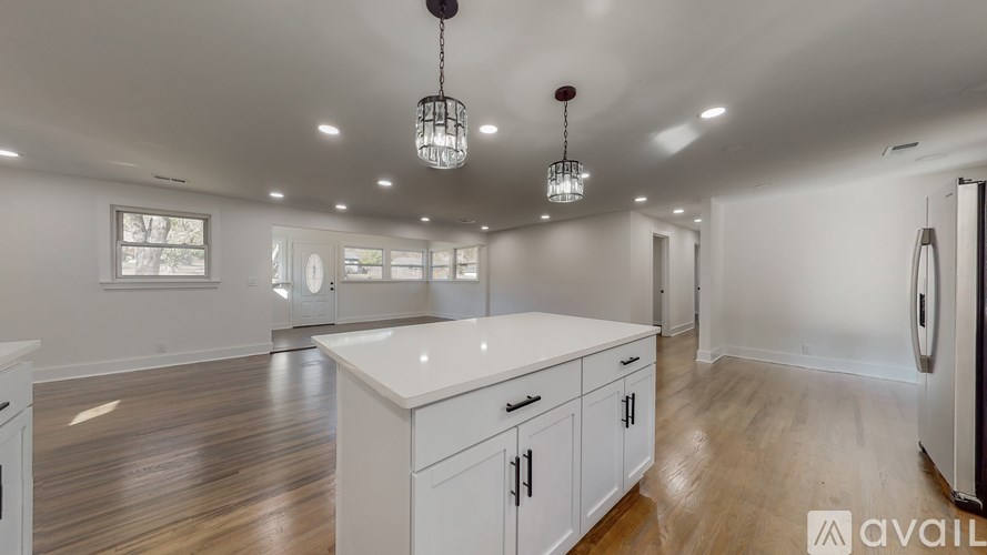 A kitchen with white cabinets and a wooden floor.