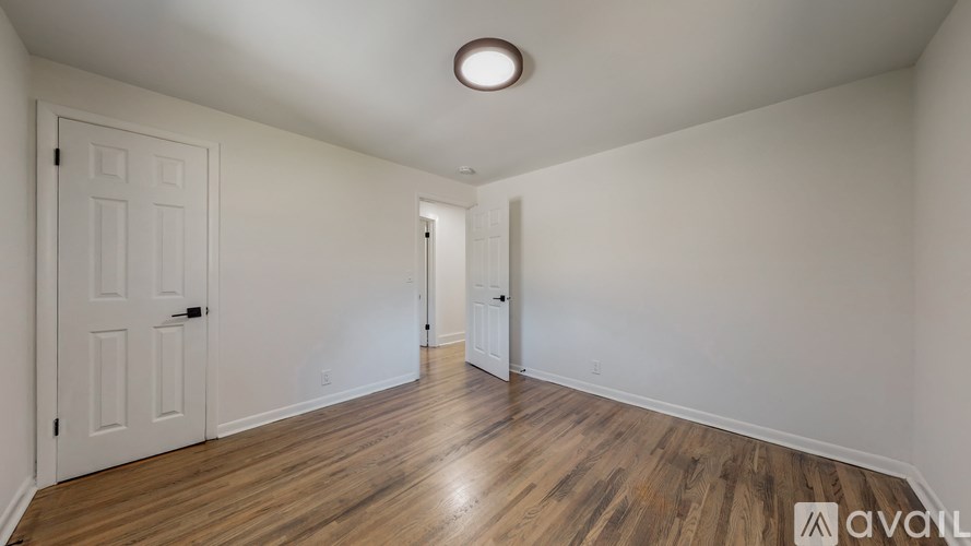 A room with wooden floors and two doors.