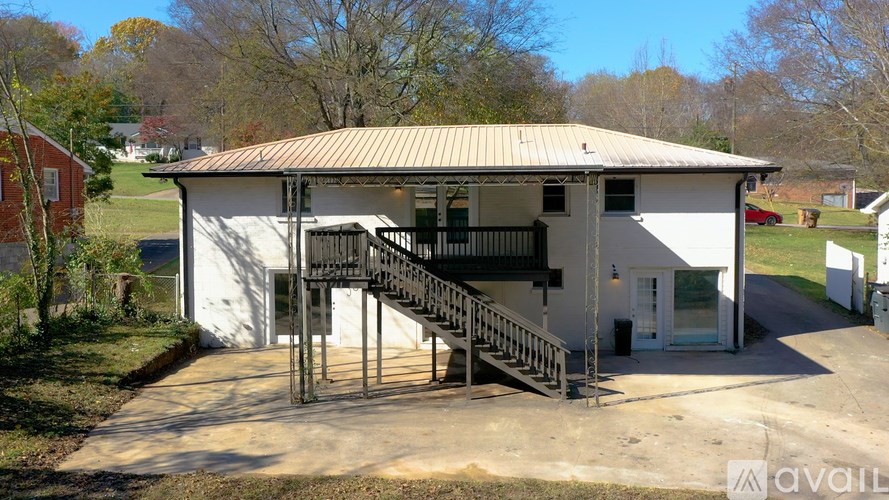 A house with a metal roof and a staircase leading to the entrance.