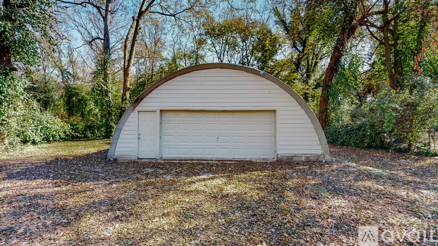 A white garage door is closed and the garage is open.