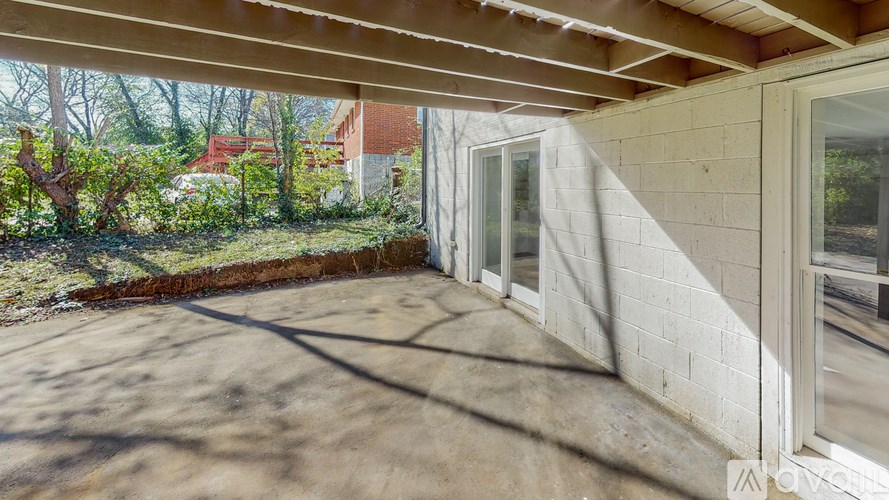 A patio with a white wall and a window.