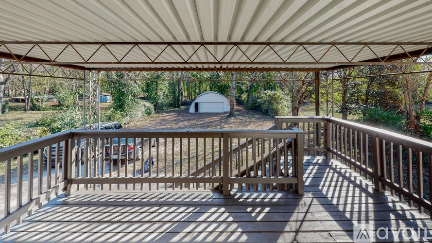 A wooden deck with a metal roof and a railing.