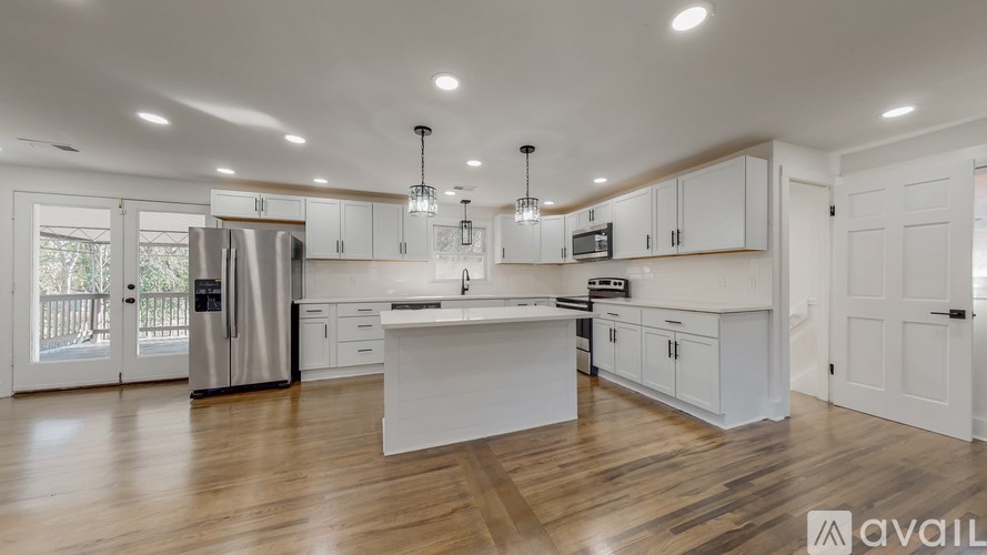 A spacious kitchen with white cabinets and a central island.