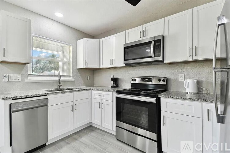 A kitchen with white cabinets and stainless steel appliances.