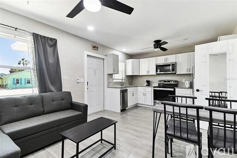 A living room with a grey couch and a black coffee table.