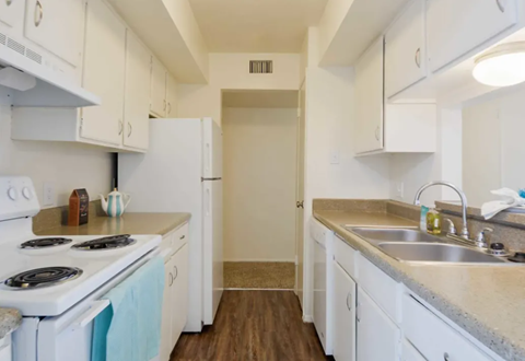 a kitchen with white cabinets and a stove and a sink