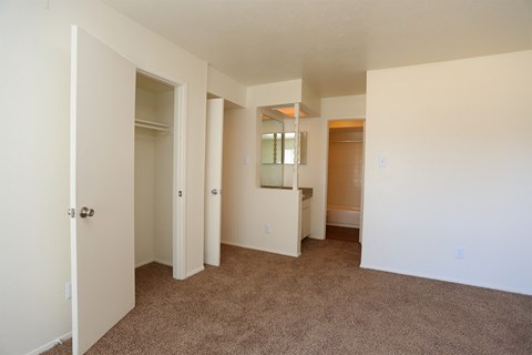 an empty living room with a carpeted floor and a bathroom
