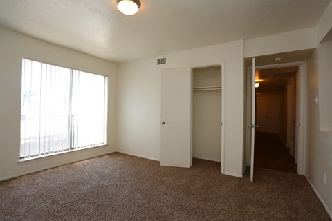 an empty living room with a large window and a closet