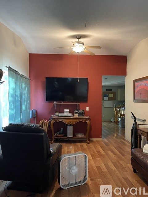 A living room with a television and a fan.