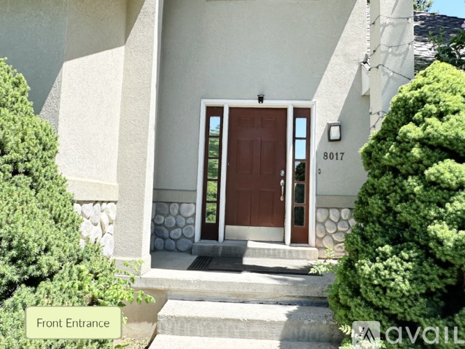 A house with a brown front door and a stone pillar.