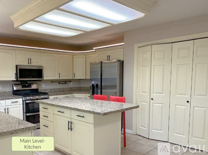 A kitchen with white cabinets and a granite countertop.
