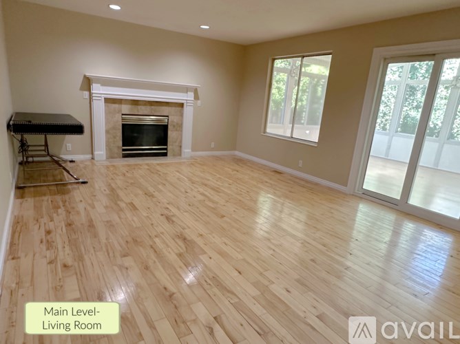 A spacious living room with a fireplace and hardwood flooring.
