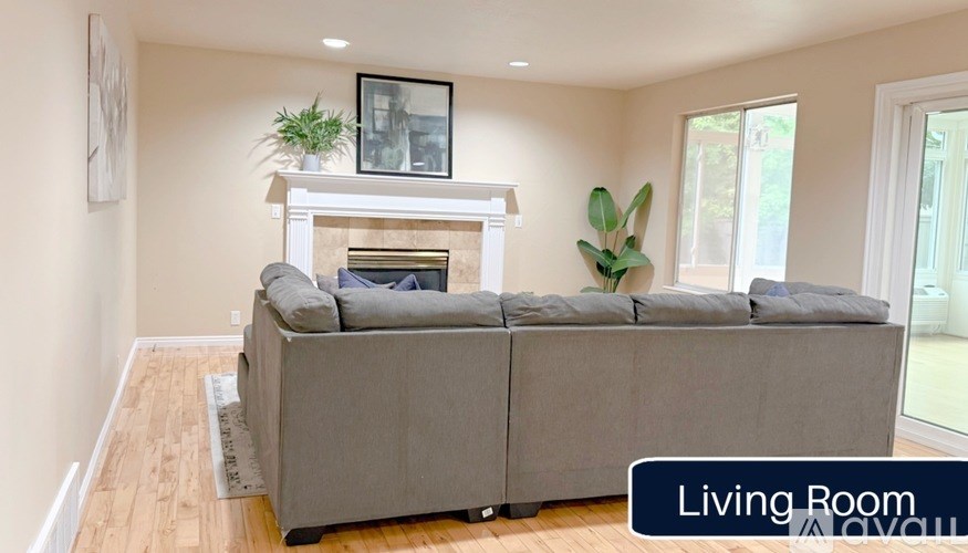 A living room with a grey couch and a fireplace.