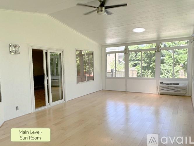 A sunroom with a ceiling fan and sliding glass doors.