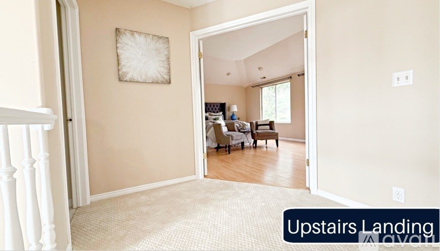 A hallway with a carpeted floor and a white door leading to a living room.