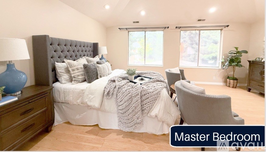 A bedroom with a large bed and a chair.