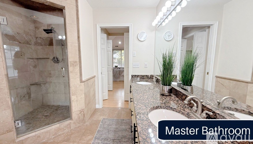A master bathroom with a walk-in shower and marble countertops.