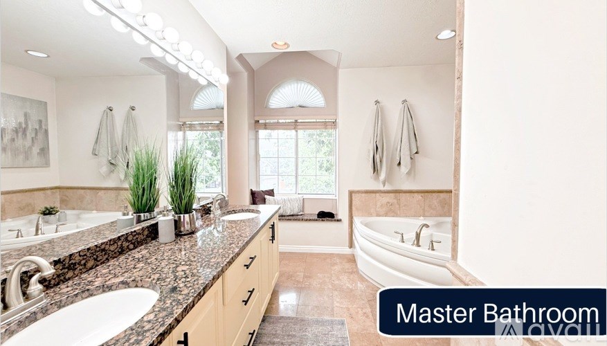 A master bathroom with a tub, sink, and towel racks.