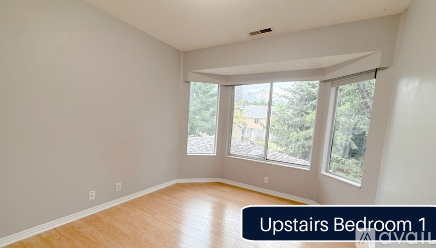 A room with a window and a wooden floor.