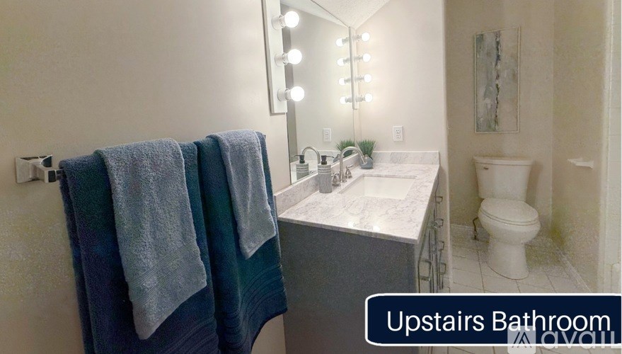 A bathroom with a sink, mirror, and toilet.