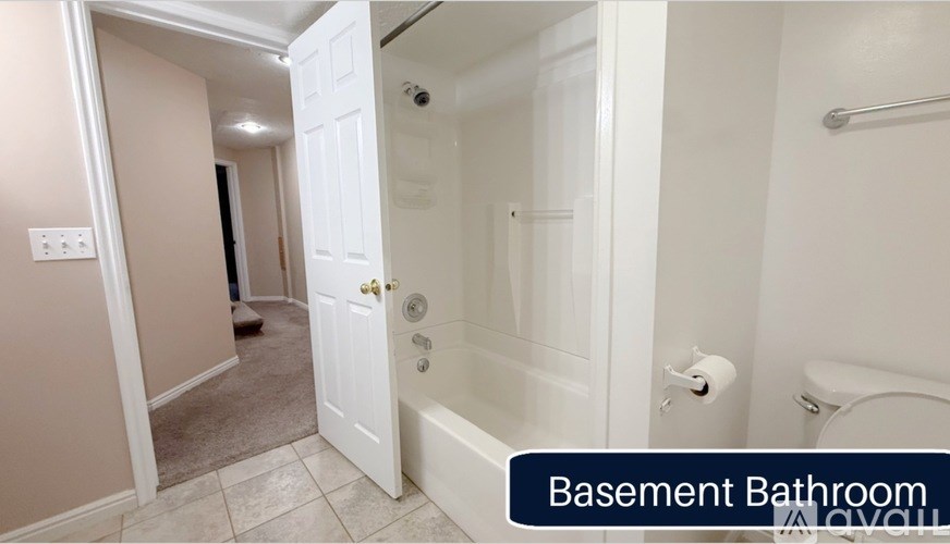 A basement bathroom with a white tub and toilet.