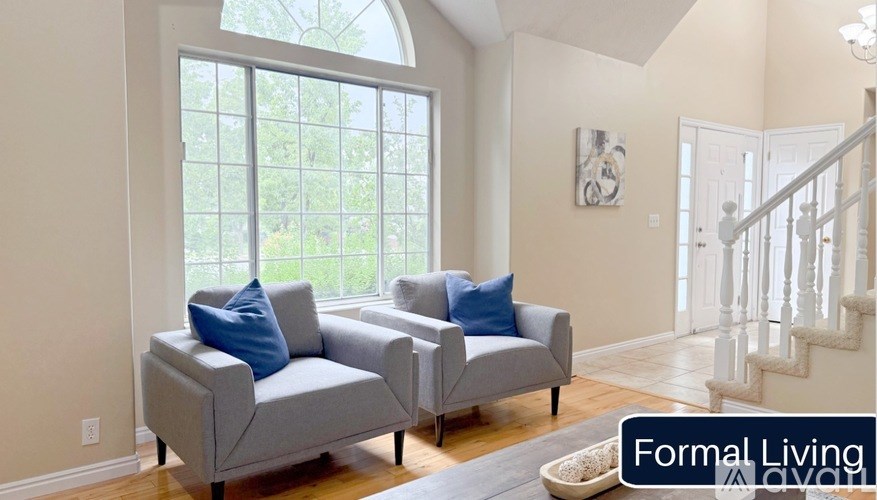 A living room with two grey couches and a staircase.