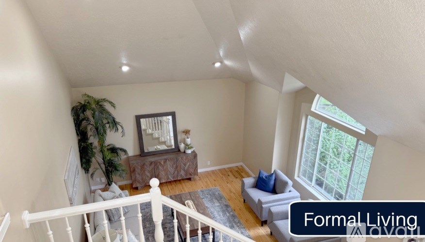 A living room with a couch, a plant, and a mirror on the wall.