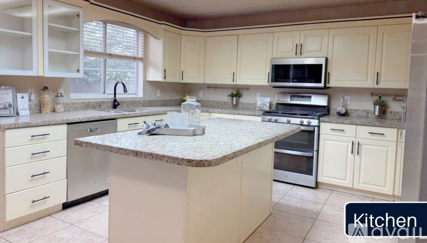 A kitchen with a granite countertop and white cabinets.