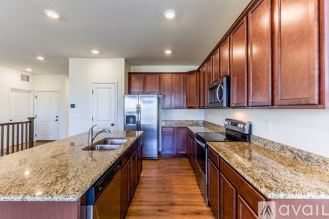 A kitchen with brown cabinets and granite countertops.