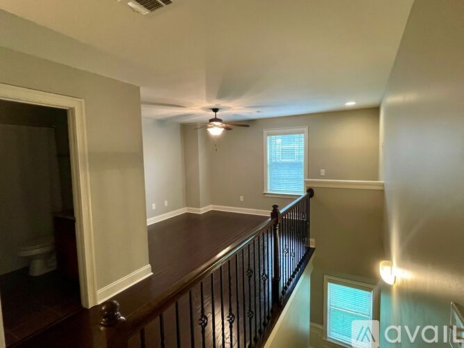 A living room with a ceiling fan and a window.