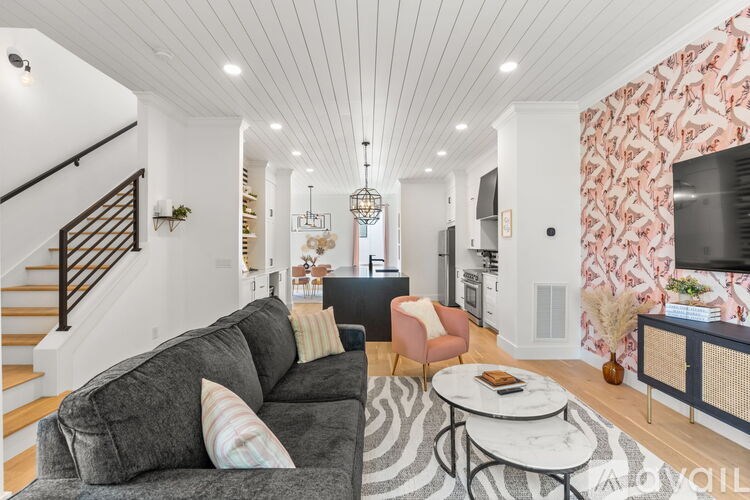 A living room with a grey couch and a zebra print rug.