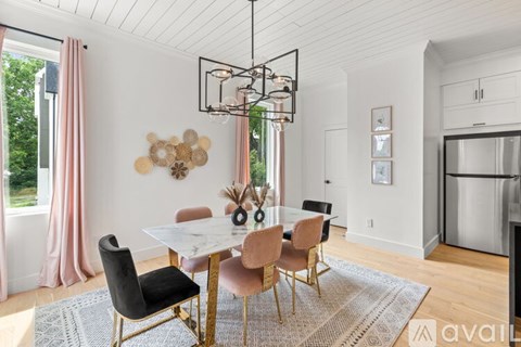 A modern dining room with a white table and chairs.