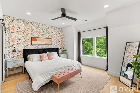 A bedroom with a floral wallpaper and a large bed.