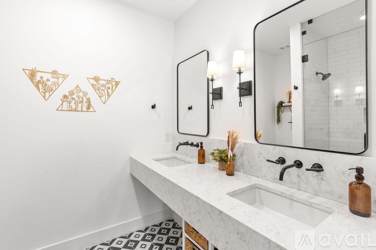 A bathroom with a marble countertop and gold wall art.