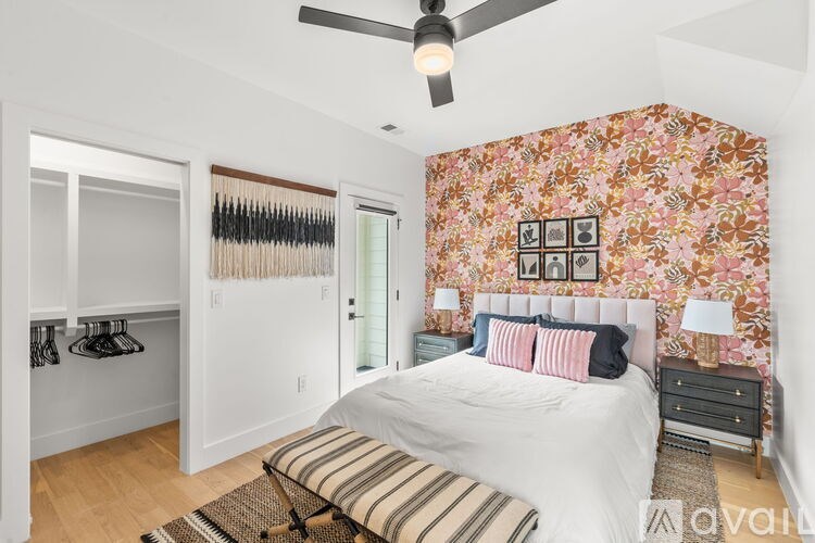 A bedroom with a floral wallpaper and a white bed.