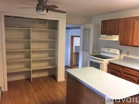 A kitchen with a white counter top and a white fridge.