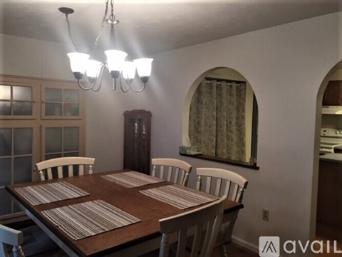 A dining room with a wooden table and chairs.