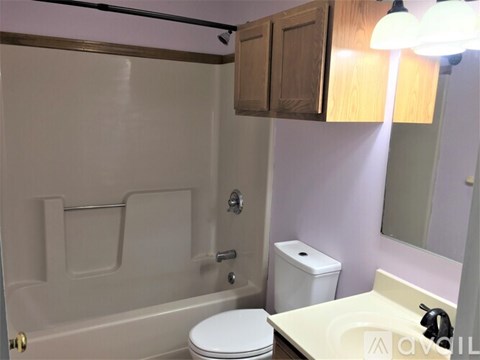 A white toilet sits next to a bathtub in a bathroom.