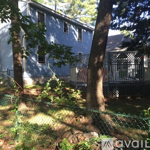 A blue house with a tree in front of it.