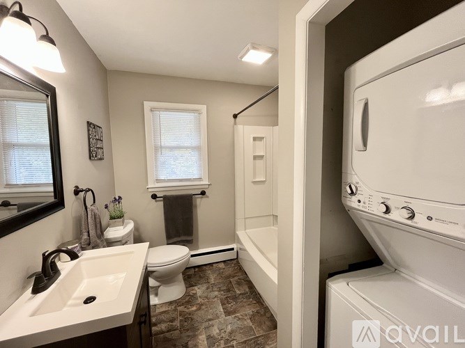A bathroom with a toilet, sink, and bathtub.