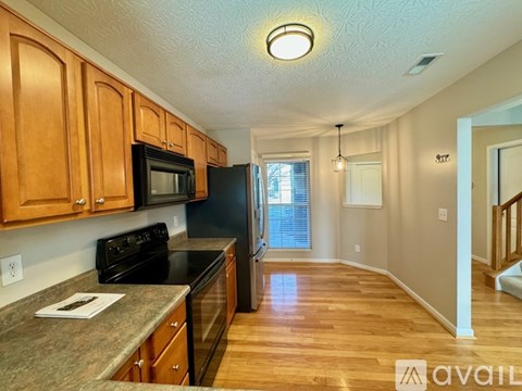 A kitchen with wooden cabinets and black appliances.