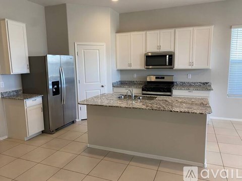 A kitchen with a granite countertop and stainless steel appliances.