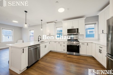 A modern kitchen with white cabinets and stainless steel appliances.