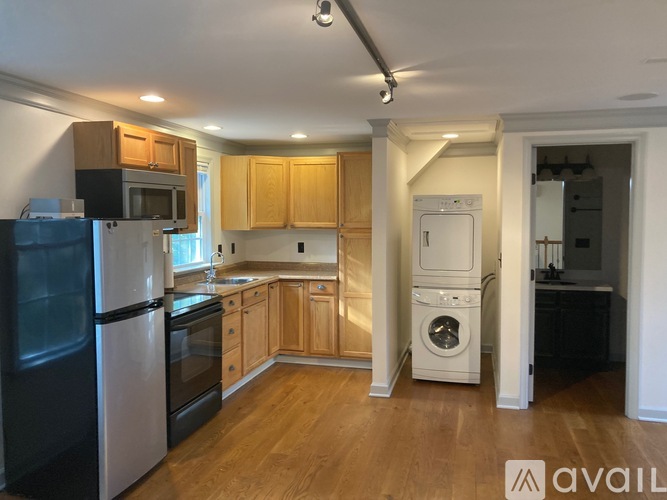 A kitchen with wooden cabinets and a white dishwasher.