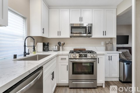 A kitchen with white cabinets and stainless steel appliances.