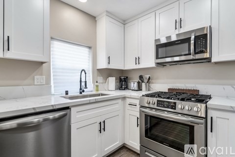 A kitchen with white cabinets and a stainless steel oven.