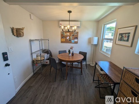 A dining room with a round wooden table surrounded by chairs.